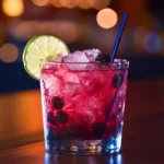 A vibrant, refreshing Baja Midnight drink served in a glass with ice and a lime slice, perfect for enjoying anytime.