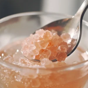 Stirring pink Himalayan salt into warm water.